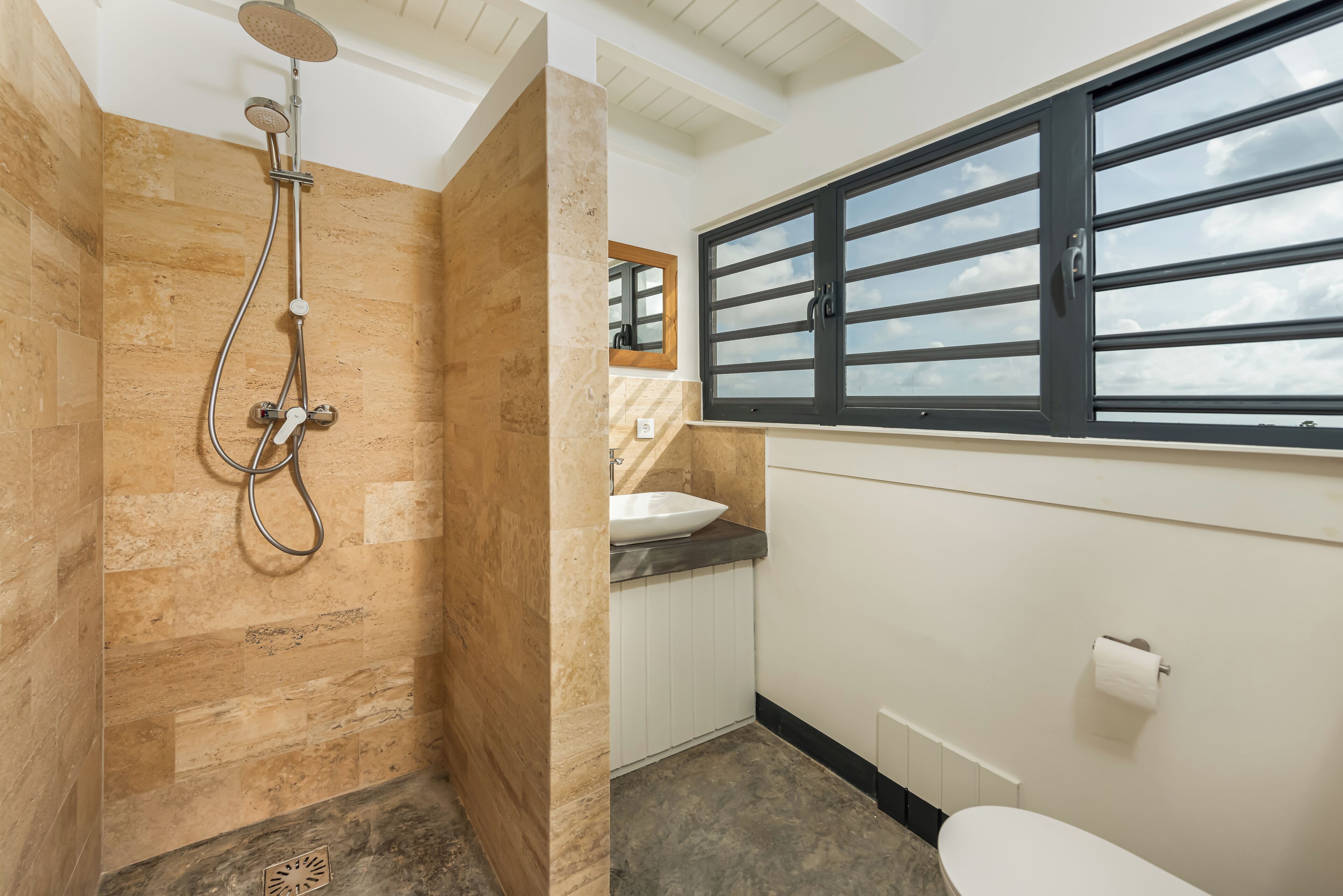 A bathroom with a shower, a sink, and a toilet.