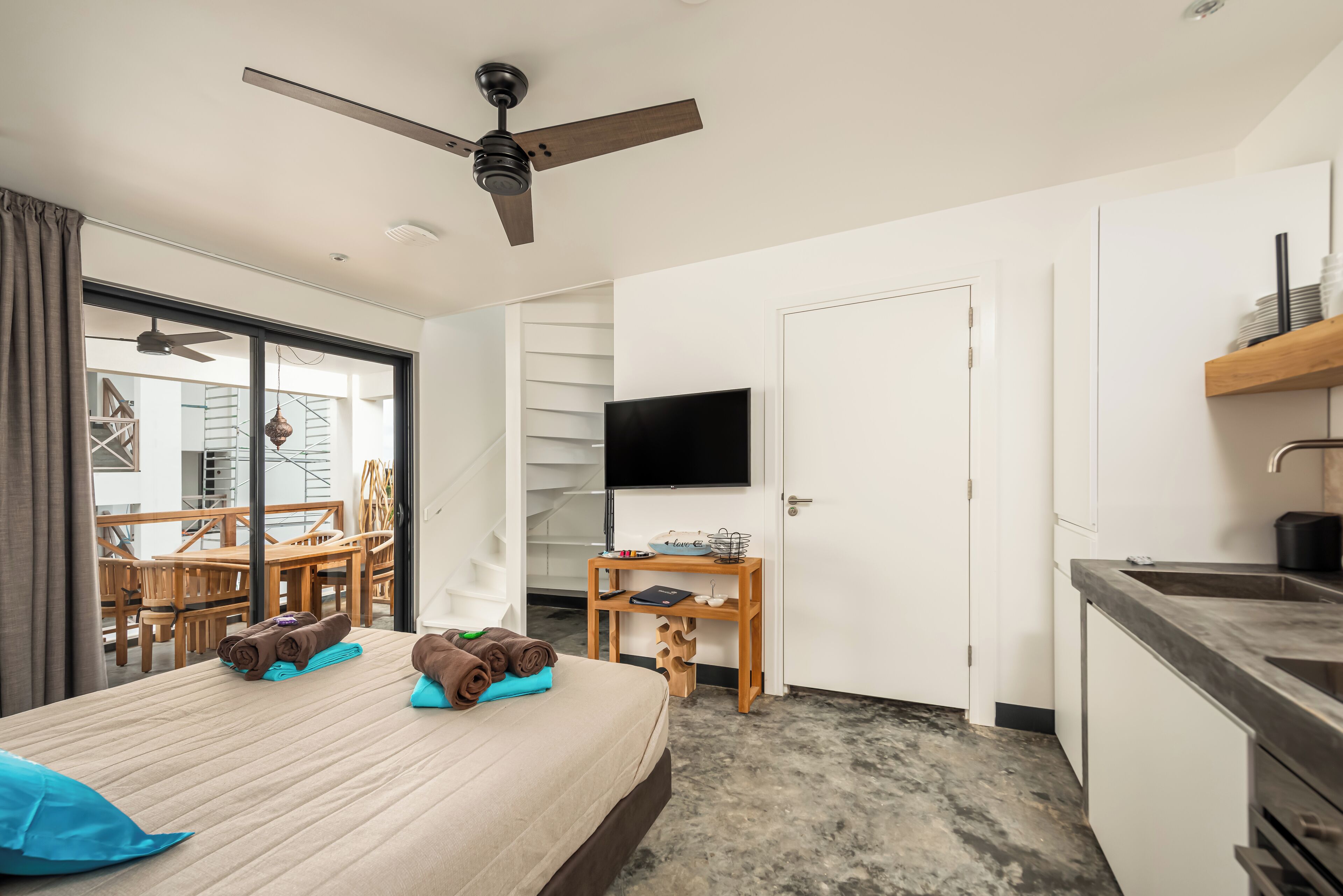 Une chambre d’hôtel avec un lit, un bureau, une télévision et une vue sur l’extérieur.