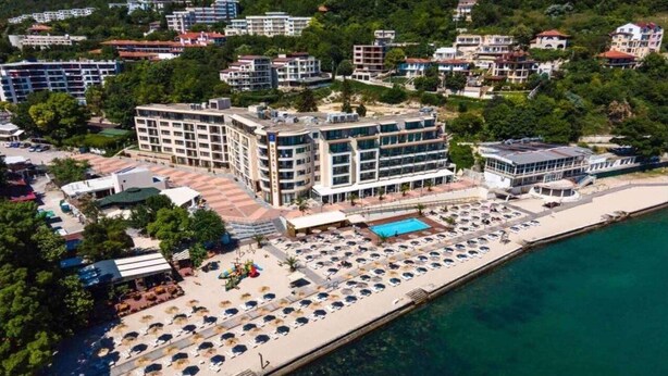 A coastal hotel with multiple floors, a swimming pool, and a beach area with sun loungers. - Royal Grand Hotel & Spa (Kavarna)