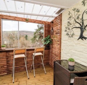 Relax in a peaceful corner with a view of the outdoors, featuring a comfortable seating area with a potted plant.