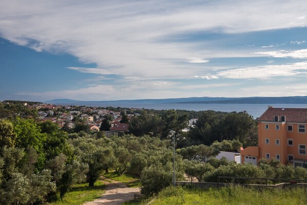 A coastal town with a view of the sea, surrounded by olive trees and residential buildings. - Apartment Salvagno - Two Bedroom Apartment with Balcony and Sea View (Punat)