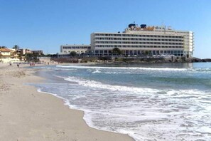 Et strandhotel med flere etager, en swimmingpool og havudsigt.
