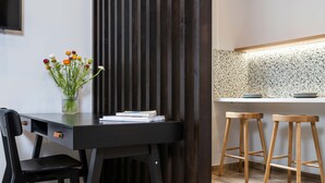 Une cuisine moderne avec une table en bois foncé, un vase de fleurs et deux tabourets en bois.