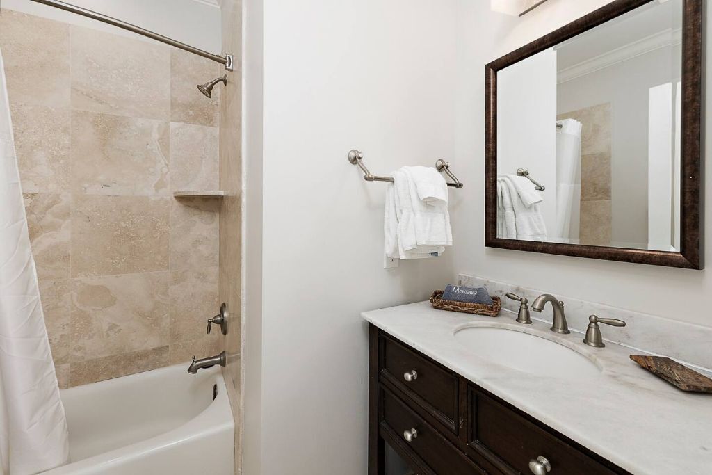 Une salle de bain avec une baignoire, un meuble-lavabo avec un miroir et un espace douche.