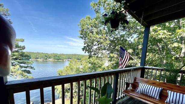 A wooden deck with a bench and potted plants, overlooking a lake and forested area. - Relax & Enjoy beautiful Sunsets!  * Boating Packages Available! (Hot Springs)