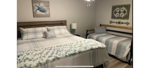 A bedroom with a large bed, a smaller bed, a nightstand, a lamp, and wall art. - Relax & Enjoy beautiful Sunsets! * Boating Packages Available! (Hot Springs)