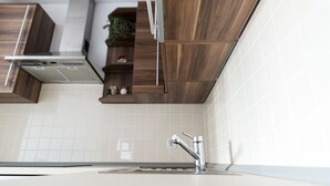 Eine moderne Küche mit Holzausstattung, einer Edelstahlspüle und einer eingebauten Dunstabzugshaube.