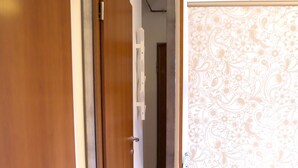 Ein Korridor mit einer Holztür, einem Spiegel und einer Wand mit Muster.