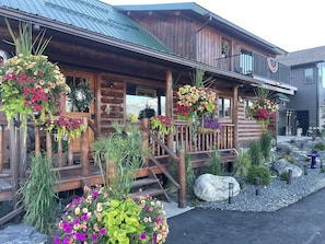 Cozy cabin-style building with a charming porch and lush surroundings.