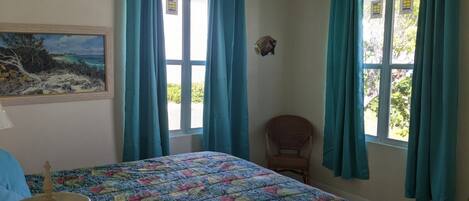 Una habitación con una cama, una silla y un cuadro en la pared.
