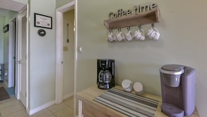 A kitchen with a coffee station, including a coffee maker, cups, and a coffee urn. - Mountain Getaway- Outdoor Pool! Hiking Trails! (Reeds Spring)