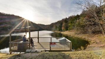 A wooden dock with a gazebo, a no trespassing sign, and a lake.