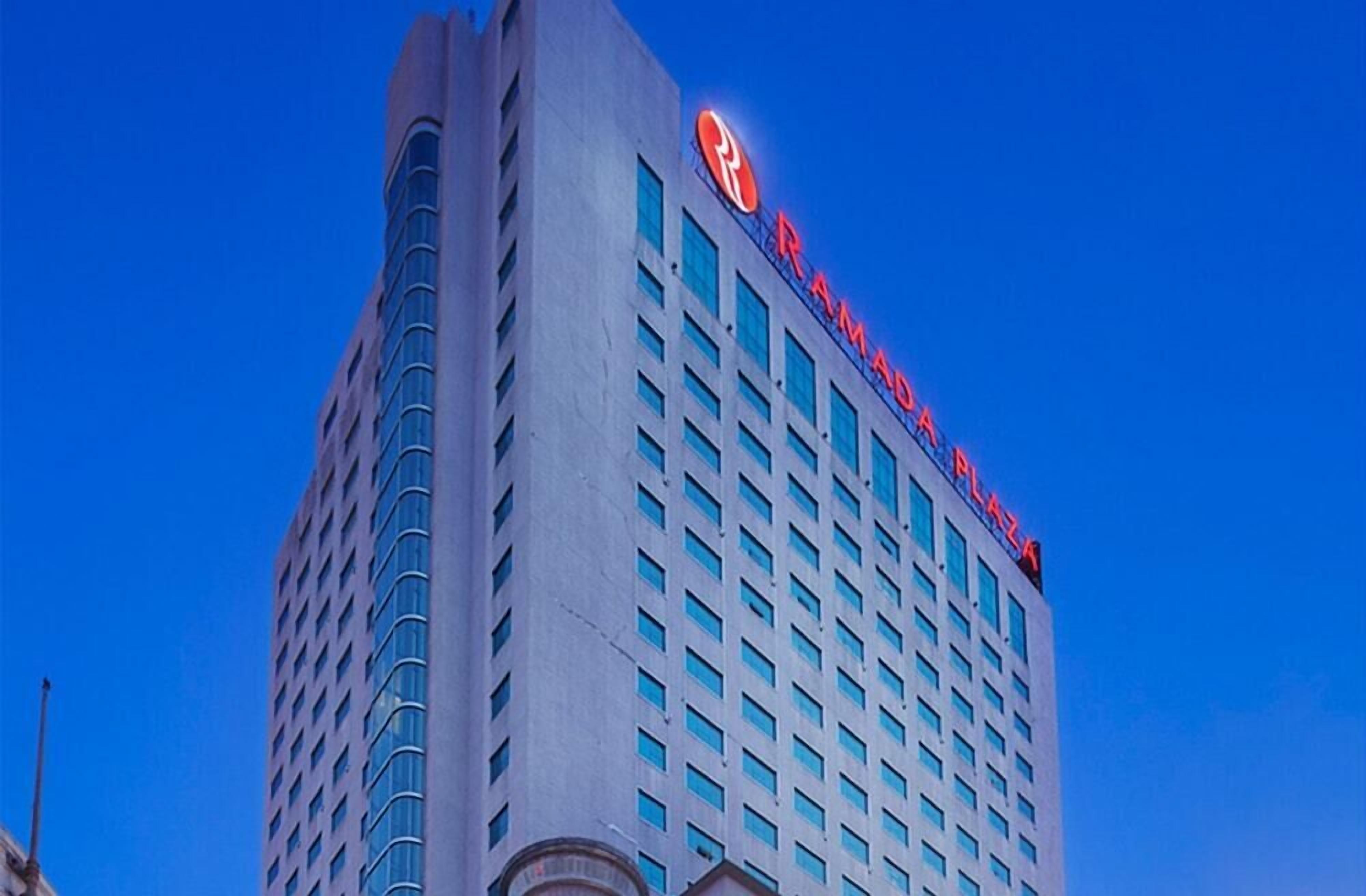 A tall building with a prominent "Ramada" sign on the top.