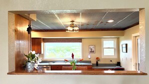A kitchen with a wooden countertop, a window with a view, a hanging light fixture, and a wall-mounted outlet. - Serenity Heights - Peaceful Country Acres with beautiful view in every direction (Osceola)