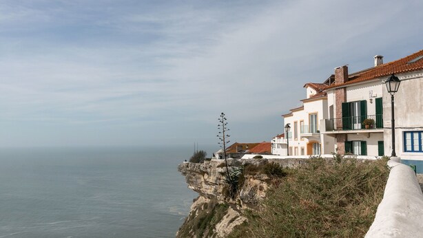 Ein Küstengebäude mit einem Balkon mit Blick auf das Meer.