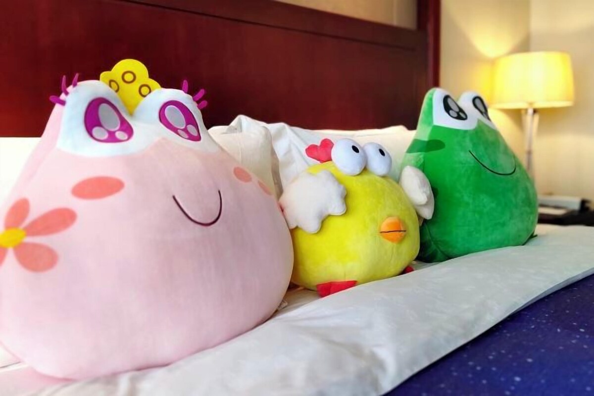 Una cama con tres peluches.