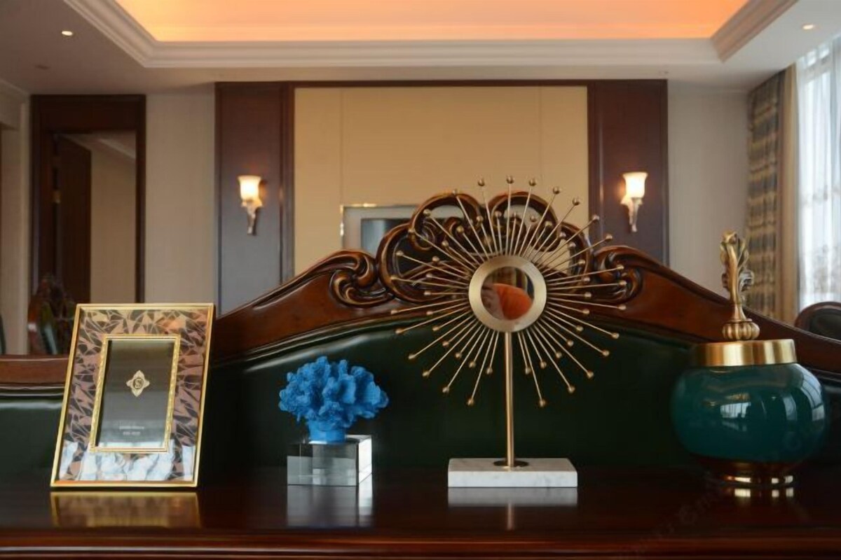 Mostrador de recepción de hotel con un certificado enmarcado, una escultura azul y un adorno de pared.