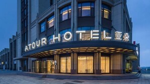 Ett hotell med en modern fasad, som har en framträdande skylt med upplysta bokstäver.