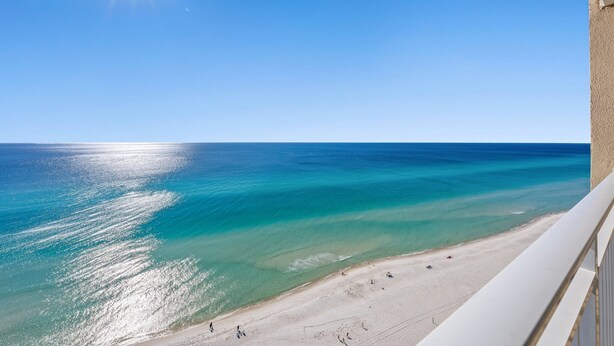 A beach with clear turquoise waters and a sandy shore.
