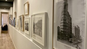 A hallway with framed photographs on the wall, including a notable image of Plaza del Callao. - Malasaña Gallery – 3-Bedroom Apartment in the City Center (Madrid)