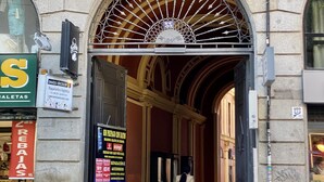An ornate entrance with a metal gate, a sign for 'Envios Tricolor' offering logistics services, and a 'Crebajas' sign indicating a train station nearby. - Madrid Styles - One-bedroom apartment (Madrid)
