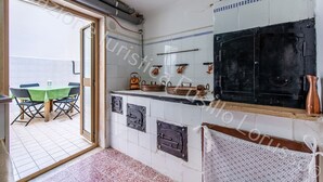 Una cocina con un ventanal grande, un comedor con mesa verde y un horno negro.