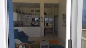 A compact living space with a kitchenette, a sofa, and a small coffee table.