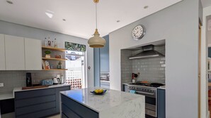 A modern kitchen with a central island, built-in appliances, and a pendant light.