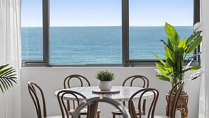 A dining area with a view of the ocean, a round table, and chairs. - Stunning Views just steps to Palm Beach (Palm Beach)
