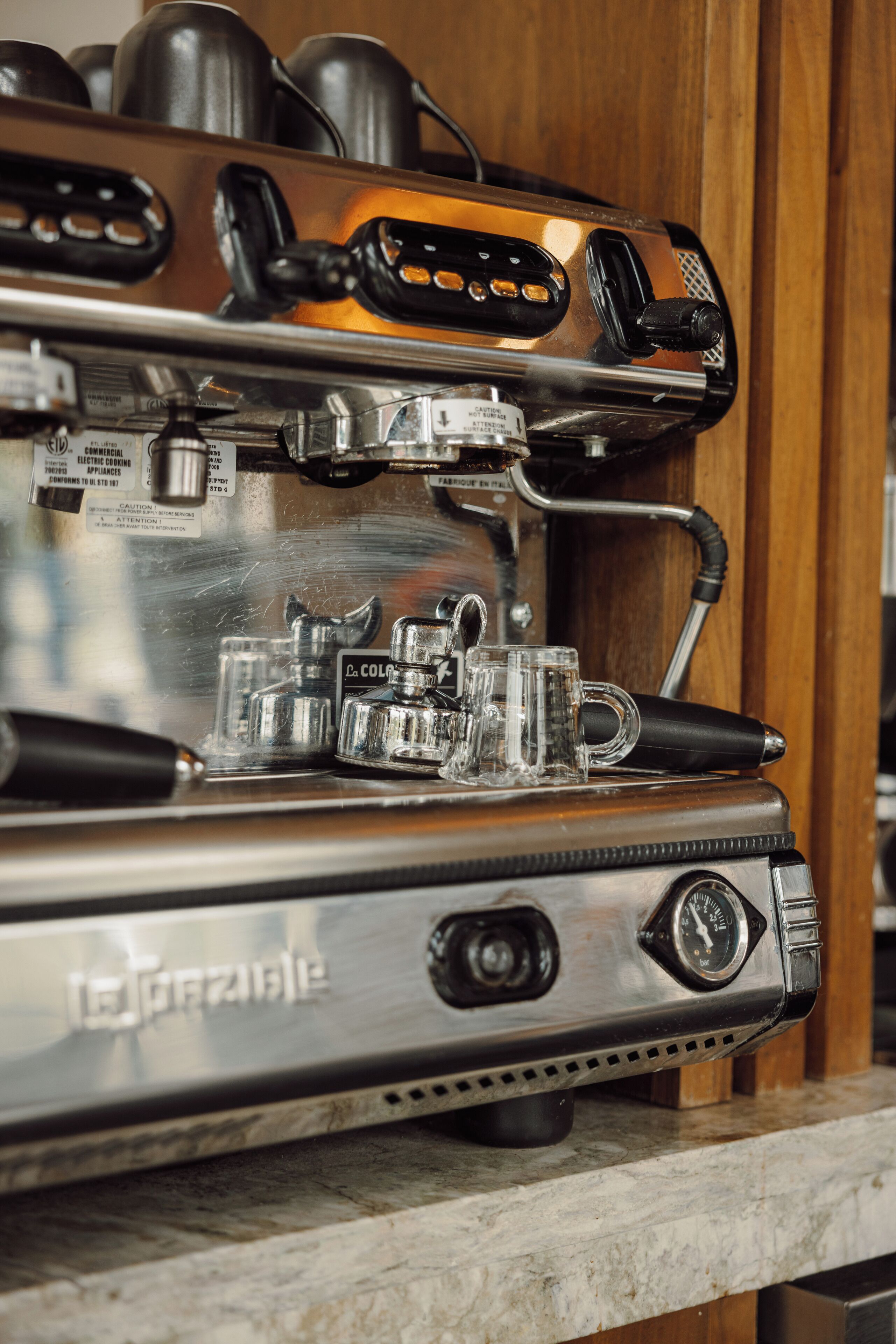Una máquina de café espresso comercial con pantalla digital y múltiples portafiltros.