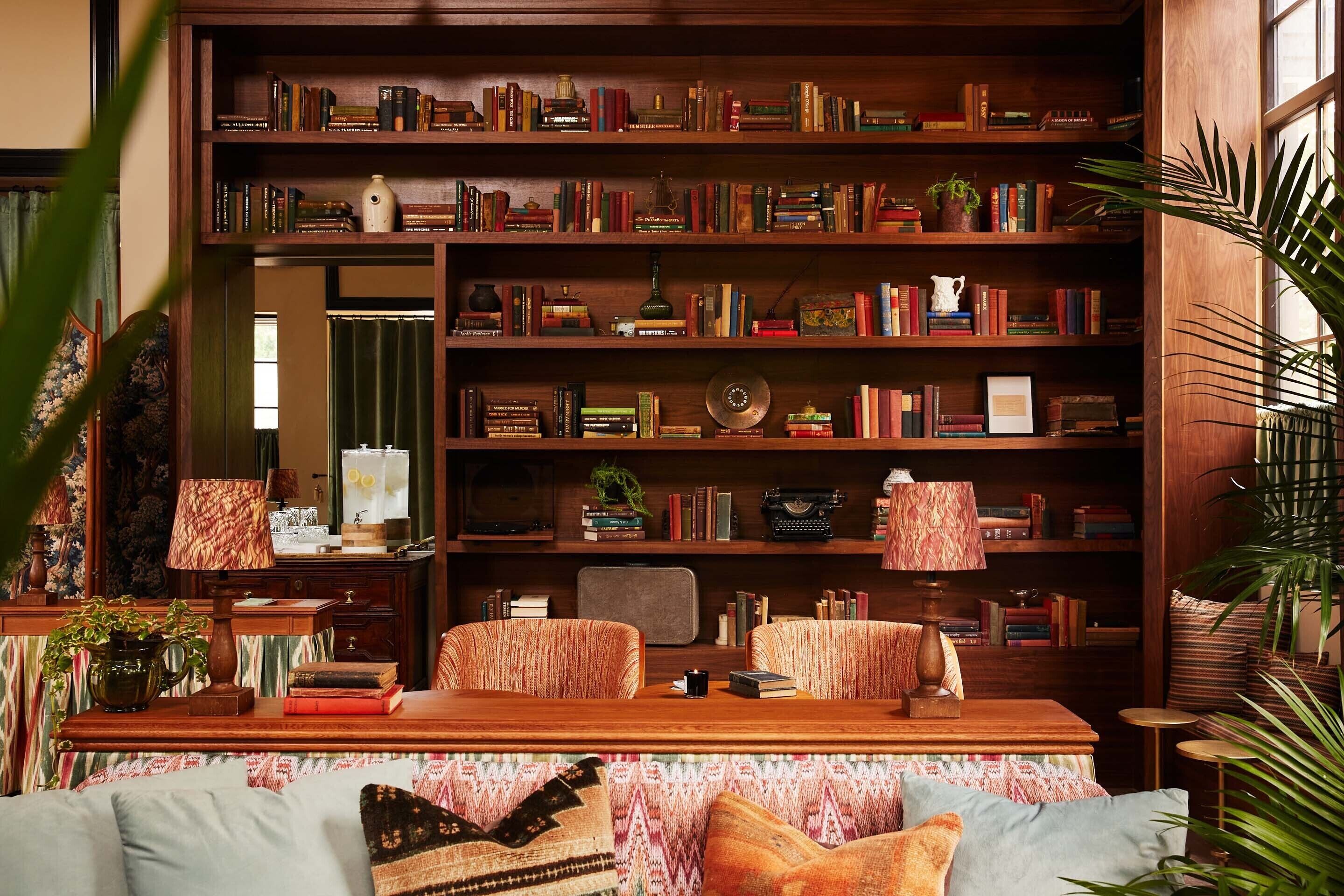 Eine gemütliche Leseecke mit einer Holzbücherwand voller Bücher, einem Vintage-Radio und einem kleinen Tisch mit Lampe.