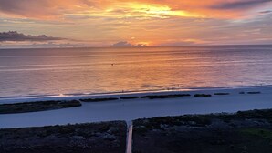A coastal sunset with calm waters and rocky outcrops. - Gorgeous beachfront studio penthouse! (Clearwater Beach)