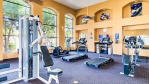 Un gimnasio con cintas de correr, máquinas de pesas y un banco.