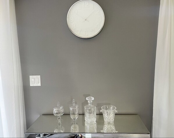 Simple, clean design with a round clock and a small table below.