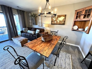 A dining area with a wooden table, metal chairs, and a chandelier.