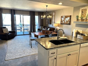 A modern kitchen with granite countertops, a built-in sink, and white cabinetry. - Journey's End-Pointe Royale Premiere Gated Resort (Branson)