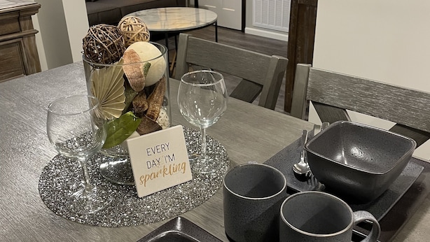 A dining table with a placemat, a glass vase with decorative items, a wine glass, a candle, and a sign that reads "Every day I'm sparkling". - 1 of 3 NEW, NEW, NEW!  Downtown Wabasha Studio - Unit #100 113 Pembroke Ave. (Wabasha)