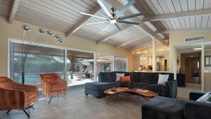A spacious living area with a ceiling fan, large windows, and a view of the outdoors. - Fully furnished Midcentury Home, 3 Bd/Den, Views, Best So PD Location (Palm Desert)