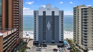 A hotel with a central atrium, a beach view, and a parking area. - Beach Front Condo! Newly Renovated! Awesome views! Private Balcony! (Gulf Shores)