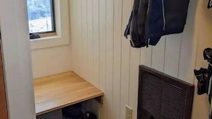 Un petit hall d’entrée fermé, avec un banc et un espace pour ranger les chaussures.