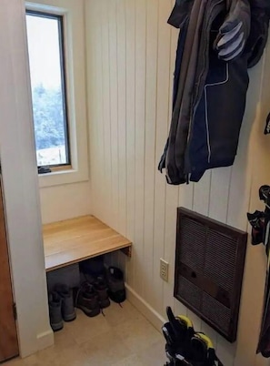 A small, enclosed entryway with a bench and shoe storage.