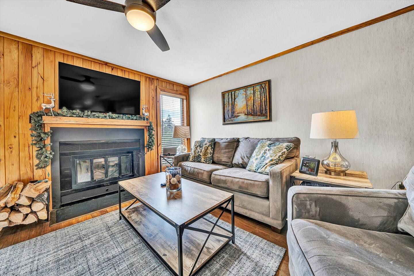 Ein gemütliches Wohnzimmer mit Kamin, einer Couch, einem Couchtisch und einem Fernseher.