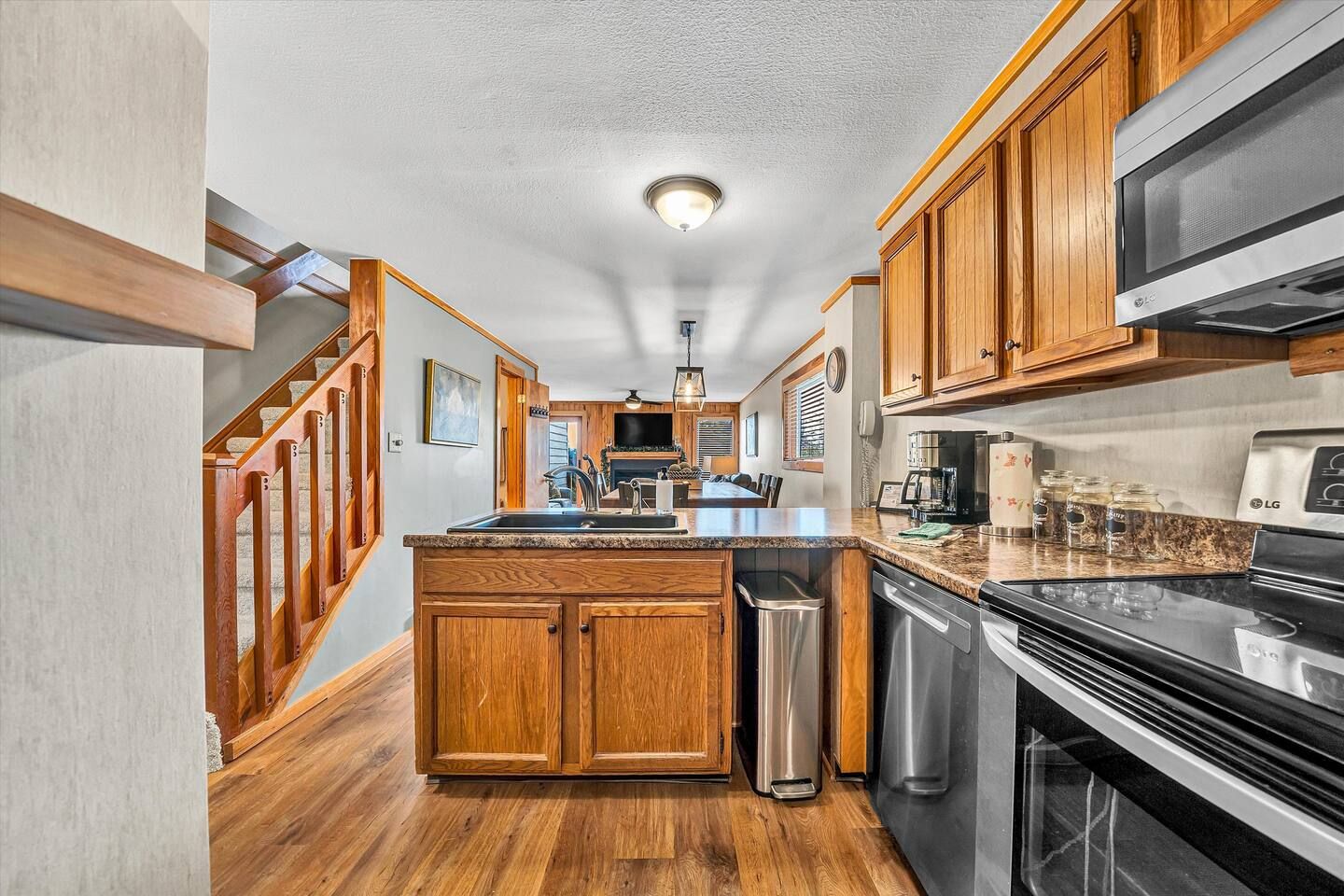 A kitchen with wooden cabinets, a stainless steel stove, and a built-in microwave.