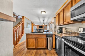 A kitchen with wooden cabinets, a stainless steel stove, and a built-in microwave.