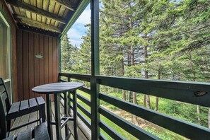 A wooden deck with a table and chairs, overlooking a forested area. - 24 Mountain Crest, Snowshoe, WV - Rustic Retreat (Snowshoe)