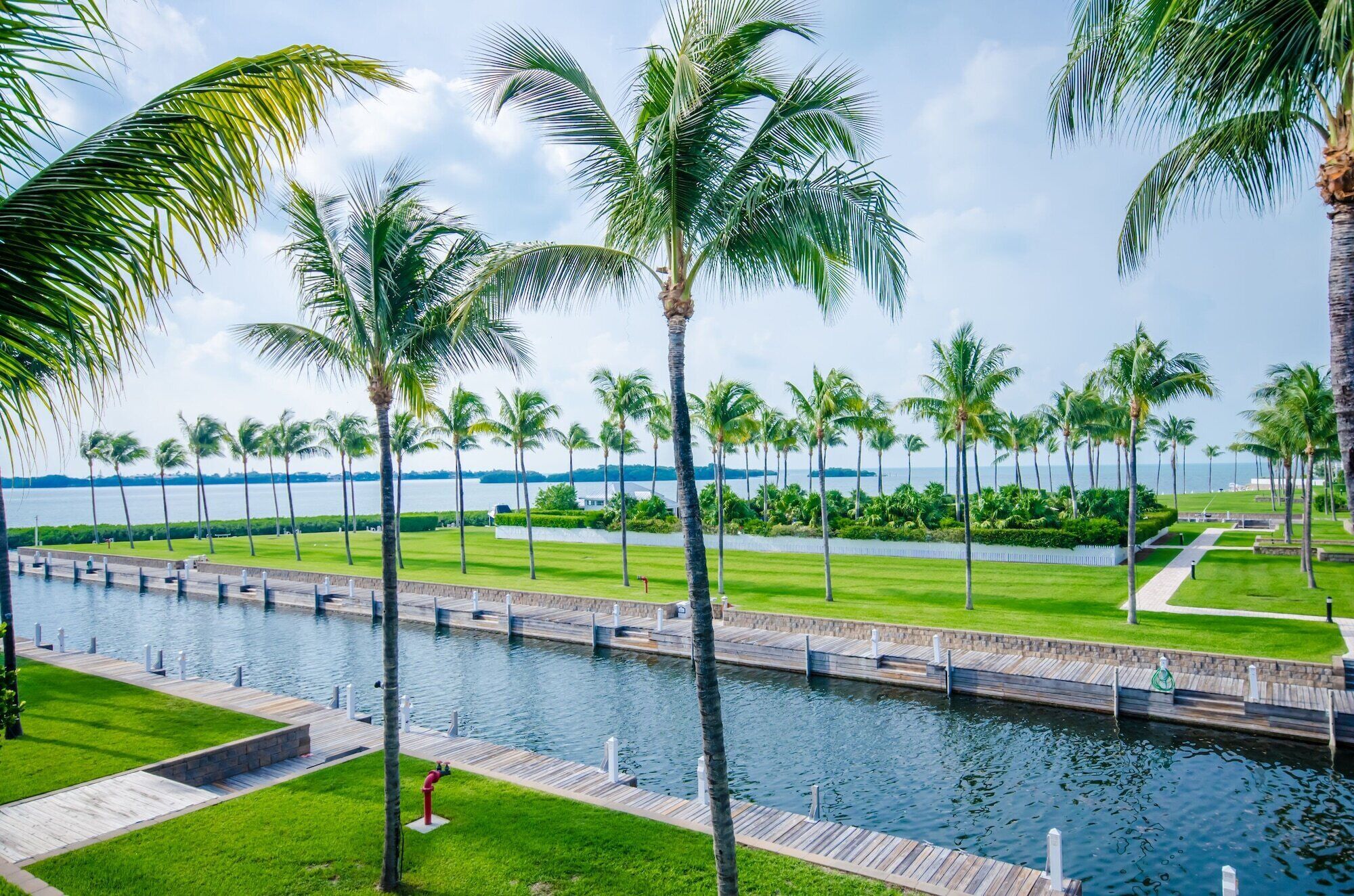 Een resort aan het water met een zwembad, palmbomen en uitzicht op de oceaan.