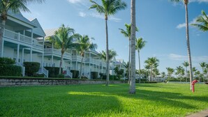 A beachfront hotel with multiple-story buildings, a well-maintained lawn, and palm trees. - Indigo Reef Resort Villas and Marina (Marathon)