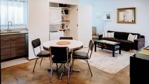 A modern kitchen with a dining area, a sofa, and a coffee table. - Modern Apt w/ Private Entry & Patio - Mtn Views (Smithfield)
