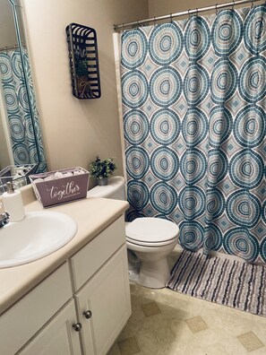 Une salle de bain équipée d’un lavabo, de toilettes et d’un rideau de douche.