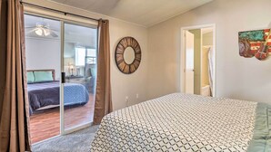 Un dormitorio con una cama, un adorno circular en la pared y vistas a otra habitación a través de una puerta corredera.